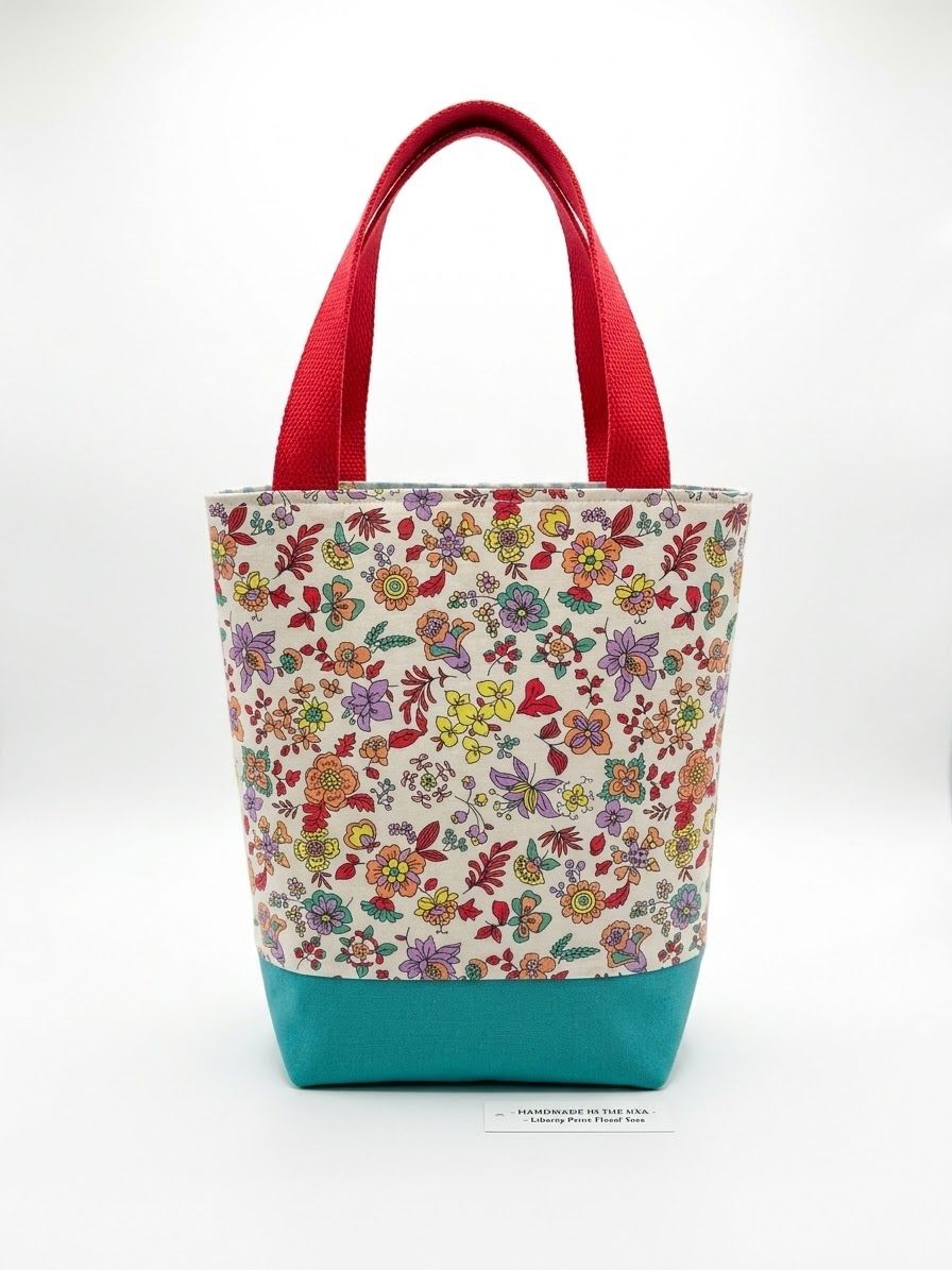 Small tote in a bright ditsy floral with a teal base and red handles